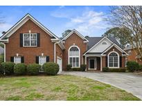 Charming two-story brick home with a well-manicured lawn, mature trees, and a classic architectural design at 1354 Old Ivy Way, Mount Pleasant, SC 29466