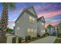 Charming two-story home with neutral siding, concrete drive, and lush landscaping against a twilight sky at 2002 Stonebraker Ln, Hanahan, SC 29410