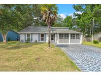 Charming single-story home featuring a screened porch and unique patterned driveway at 204 Tram Blvd, Summerville, SC 29486