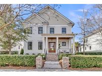 Charming two-story home featuring a welcoming front porch and manicured landscaping at 213 Amberjack Ln, Charleston, SC 29492