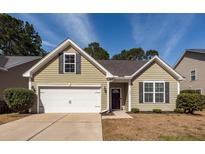 Charming single-story home with green siding, attached garage and well-maintained lawn at 322 Freeland Way, Moncks Corner, SC 29461