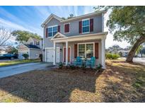 Charming two-story home with gray siding, red shutters, and inviting front porch with light blue Adirondack chairs at 3621 Locklear Ln, Mount Pleasant, SC 29466