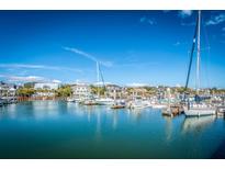 Picturesque marina view with boats docked against a bright blue sky and waterfront homes at 401 Yacht Harbor Ct, Isle of Palms, SC 29451