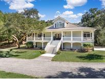 Charming two-story traditional home featuring a large wrap around porch and a beautiful lawn at 5991 Joseph Blake Ln, Wadmalaw Island, SC 29487