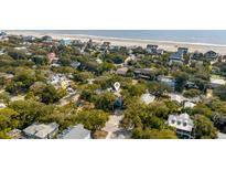 Breathtaking aerial view of a coastal home nestled among lush trees near the beach at 619 E Erie Ave, Folly Beach, SC 29439