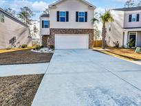 Charming two-story home with a wide driveway, front lawn, and a two-car garage at 669 Silver Spruce St, Summerville, SC 29486