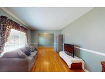 A bright and airy living room featuring hardwood floors, a grey sofa, and plenty of natural light at 105 Tasker Dr, Summerville, SC 29485