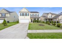 Traditional two-story home boasts a manicured lawn, attached two-car garage and welcoming front porch at 108 Weeping Cypress Dr, Moncks Corner, SC 29461