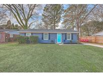 Charming single-story home with blue brick and a bright turquoise front door, complemented by a lush lawn at 111 Summit Ave, Goose Creek, SC 29445