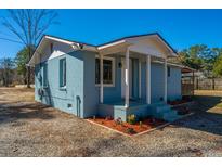 Charming bungalow with a cozy porch and a colorful flower bed at 117 Roberts Rd, Summerville, SC 29483