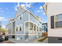 Charming two-story home with blue siding, white trim, and a inviting front porch at 169 Jackson St, Charleston, SC 29403