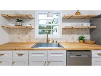 Bright kitchen features butcher block counters, floating shelves, and stainless steel dishwasher at 201 Driver Ave, Summerville, SC 29483