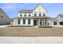 Charming two-story home with a covered front porch and manicured landscaping in a suburban neighborhood at 2064 Parish House Cir, Johns Island, SC 29455