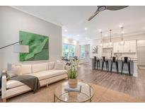 Inviting living room featuring a comfortable sofa, stylish decor, and an open layout to the kitchen and dining area at 3092 Emma Ln, Mount Pleasant, SC 29466