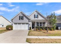 Charming single-Gathering home featuring a well-manicured lawn, two-car garage, and inviting front porch at 3129 Cross Vine Ln, Summerville, SC 29483