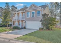 Charming two-story home with a front porch, a second story balcony and an attached garage at 339 Cicadas Song, Moncks Corner, SC 29461