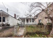 Exterior shot of home with covered porch, fenced front yard, and adjacent houses at 355 Nassau St, Charleston, SC 29403