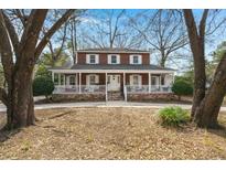 Charming two-story home with a welcoming wrap-around porch and mature trees at 49 Crosscreek Dr, Charleston, SC 29412