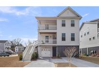 Charming three-story beach house with white siding, dual balconies, and a convenient drive-under garage at 7029 Elm Tree Ln, Johns Island, SC 29455