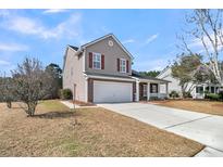 Charming two-story home featuring a two car garage, red shutters, and a well-maintained lawn at 105 Waylon Dr, Summerville, SC 29483