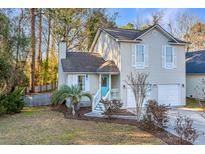 Charming two-story home featuring a light blue front door, light beige siding, and a well-manicured front yard at 1253 Lakefront Dr, Charleston, SC 29412