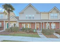 Charming two-story townhome with brick accents, complemented by a sidewalk and lush green lawn at 128 Hornby Cir, Goose Creek, SC 29445