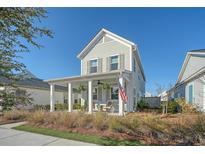 Charming two-story home featuring a inviting front porch with traditional design elements and a well-manicured lawn at 142 Midtown Ave, Summerville, SC 29486