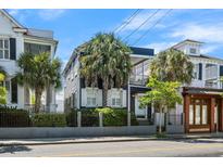 Charming two-story home featuring a small balcony, palm trees, and beautiful landscaping at 167 Spring St # A/B, Charleston, SC 29403