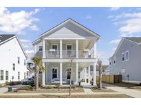 Charming two-story home with a welcoming double front porch and manicured landscaping at 225 Bird Song Path, Summerville, SC 29485