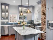 Well-lit kitchen features a large island, stainless steel appliances, and grey cabinets at 25 Logan St, Charleston, SC 29401