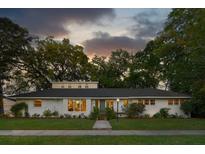 Charming one-story home with white brick exterior, manicured lawn, and mature trees, creating a warm and inviting curb appeal at 30 Darlington Ave, Charleston, SC 29403