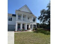 Charming two-story white home with a welcoming front porch and well-manicured lawn at 3213 Great Egret Dr, Johns Island, SC 29455