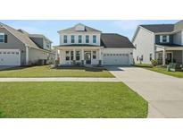 Charming two-story home with white siding, a well-manicured lawn, and an attached two-car garage at 490 Rowley Ln, Summerville, SC 29486