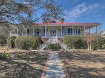 Charming two-story home with a red roof, brick pathway, covered porch, and landscaped front yard at 547 Island Walk, Mount Pleasant, SC 29464