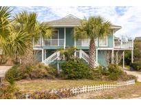 Charming teal two-story home featuring white railings, a welcoming entrance, and mature palm trees in the yard at 6 4Th Ave, Isle of Palms, SC 29451