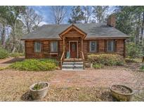Charming log cabin home with inviting front porch and brick pathway at 8262 Fairview Nursery Rd, Hollywood, SC 29449