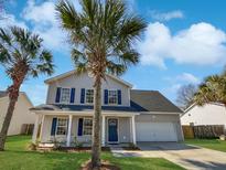 Charming two-story home with gray siding, blue shutters, and a well-manicured lawn with mature palm trees at 8987 Buck Run Ct, North Charleston, SC 29406