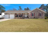Charming brick home featuring an attached two-car garage and a well-manicured front yard with ample space for outdoor activities at 112 Lois Cir, Moncks Corner, SC 29461