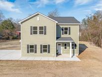 Charming two-story home with a welcoming facade and well-maintained landscaping and black shutters at 1738 N N Hwy 52, Bonneau, SC 29431