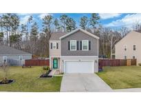 Charming two-story home featuring a well-manicured lawn, neutral siding, and an attached garage at 212 Goshen Rd, Moncks Corner, SC 29461