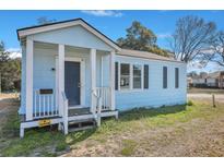 Charming light blue one-story home featuring a covered front porch with simple white railings and columns at 2125 Cosgrove Ave, North Charleston, SC 29405