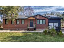 Charming brick home with a well-maintained lawn and solar panels on the roof at 2350 Etiwan Ave, Charleston, SC 29414