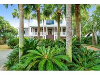 Beautiful two-story home with inviting porch and lush tropical landscaping at 2820 Jasper Blvd, Sullivans Island, SC 29482