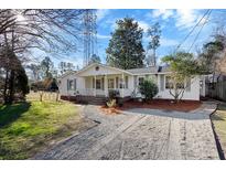 Charming single-story home featuring a welcoming front porch and a gravel driveway at 308 W 2Nd North St, Summerville, SC 29483