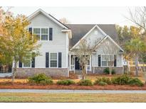 Charming two-story home with brick accents, lush landscaping, and a welcoming front porch at 323 Shadowmoss Parkway, Pkwy, Charleston, SC 29414