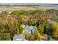 An aerial view of condominiums with marsh views and mature trees in a beautiful community setting at 60 Fenwick Hall Allee # 521, Johns Island, SC 29455