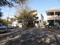 Charming two-story home with light gray siding and front yard trees in a neighborhood setting at 668 Rutledge Ave, Charleston, SC 29403