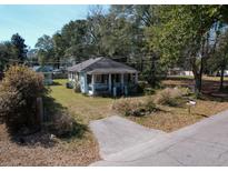 Charming single-story home with a covered porch and a well-maintained front yard at 727 Spark St, Mount Pleasant, SC 29464