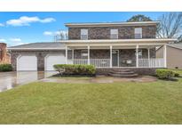 Two-story brick home featuring a spacious porch, two-car garage and well manicured lawn at 828 Longbranch Dr, Charleston, SC 29414