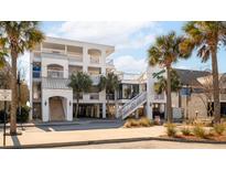 Coastal condo building featuring multiple stories, white exterior and staircase at 1004 Ocean Boulevard # 110, Isle of Palms, SC 29451